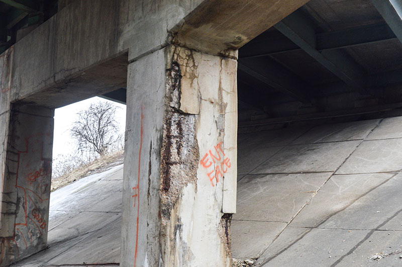 Picture of underneath of highway overpass crumbling.