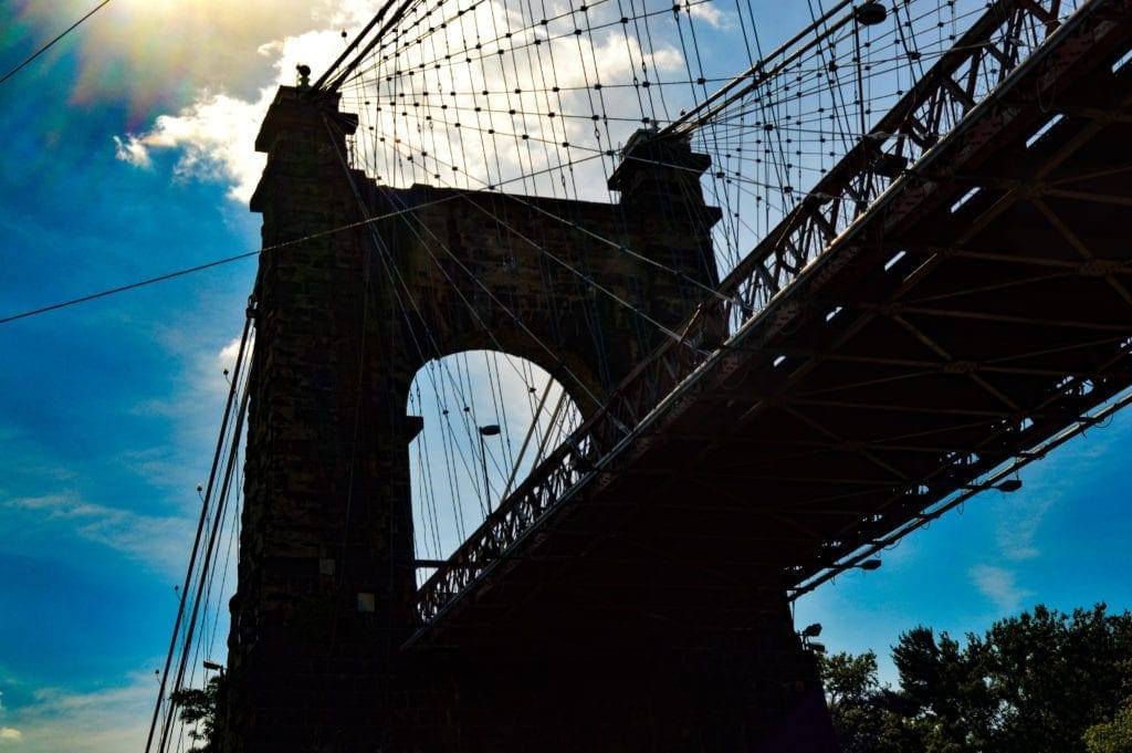 A scenic photo of the Wheeling Suspension Bridge taken from the Ohio River.