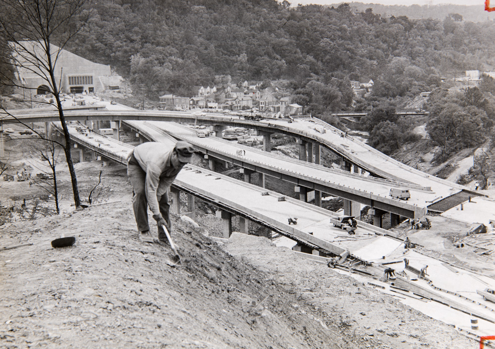 A worker continuing to rehab a cemetery after it was split in half.