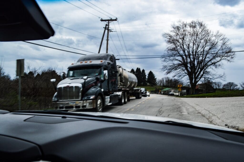 A photo of a SUV passing a massive water truck on a back road in Marshall County.