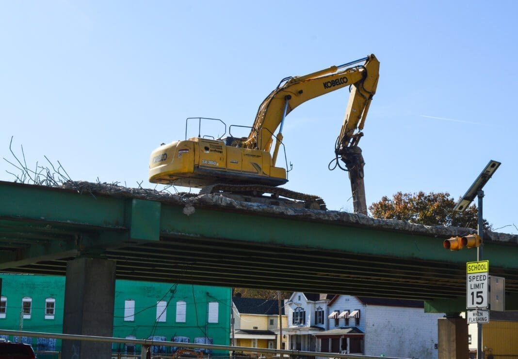 Demo machinery atop a bridge along an interstate.