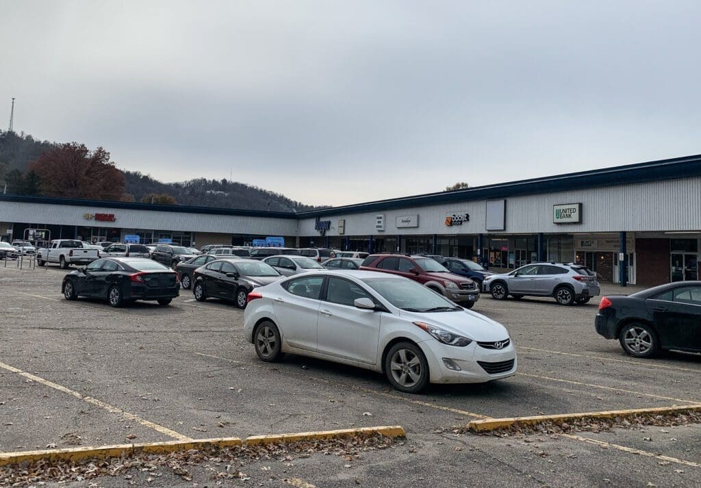 A shopping plaza with a crowded parking lot.