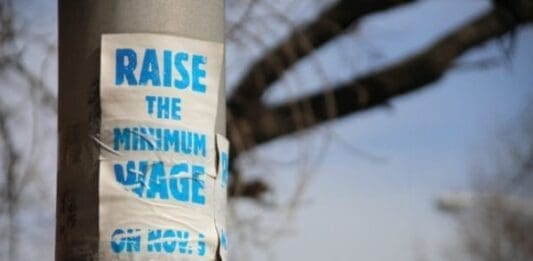 A worn sign demanding an increase in the federal minimum wage.