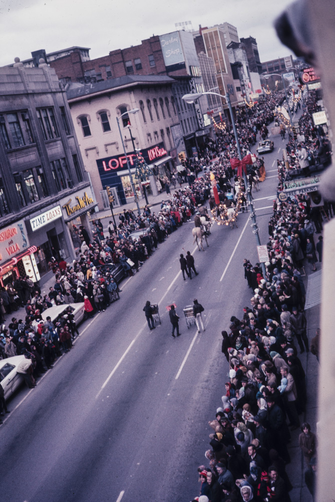 A large crowd gathers for a Christmas parade.