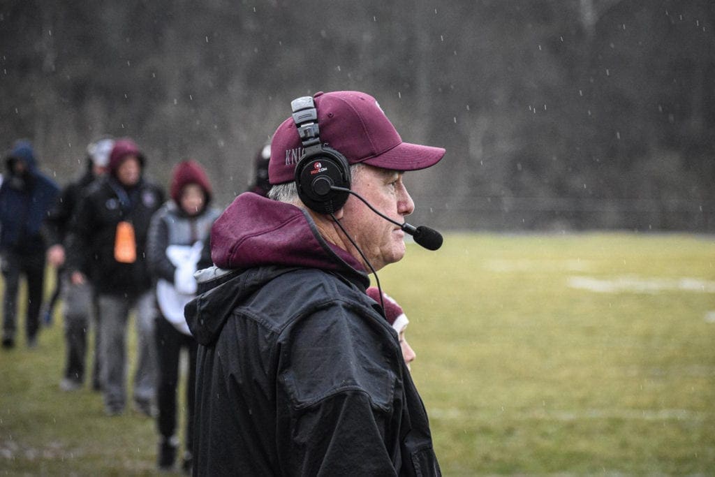 A high school football coach on the sidelines during a game.