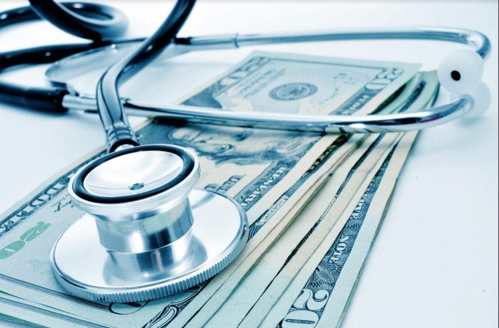 A photo of money and a stethoscope.