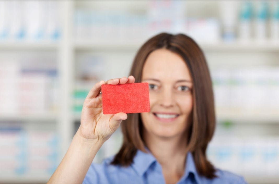 A picture of a lady holding a discount near the front of her face.