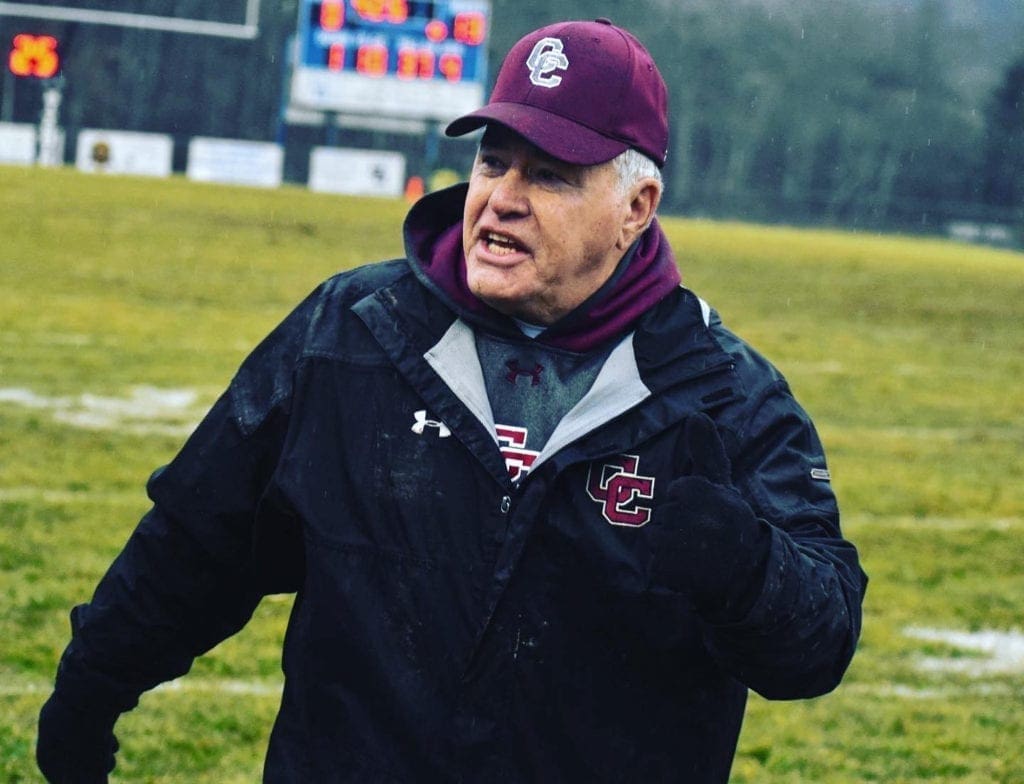 A high school football coach encouraging his team.