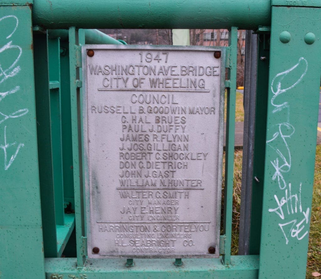 A photo of a bridge plaque that lists city officials.