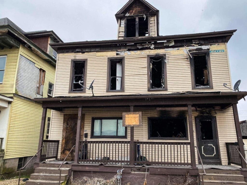 The burned out house in a neighborhood.