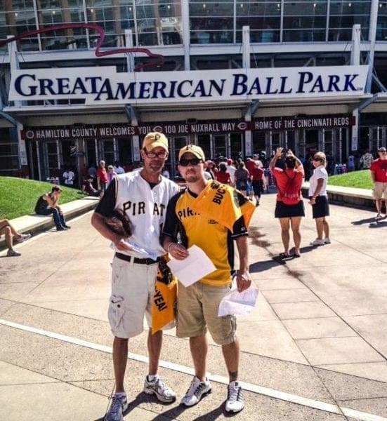 A man and his son in front of a ballpark.