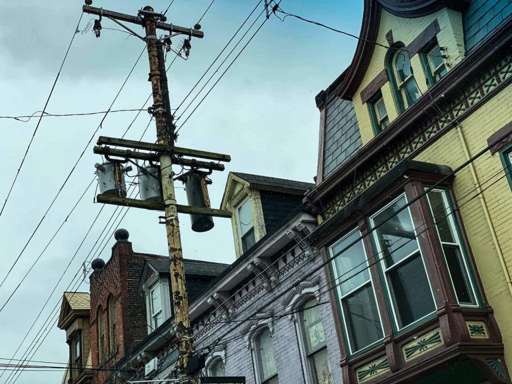 A photo of electrical transformers near a residence.