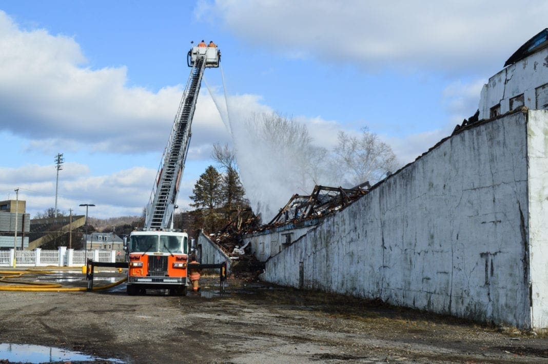 A ladder truck spraying a fire scene.