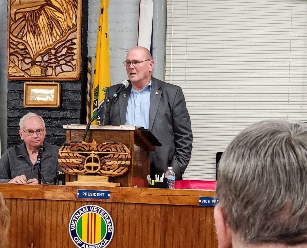 A photo of man speaking a room of people.