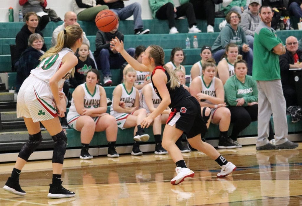 Two female basketball players go after a loose ball.