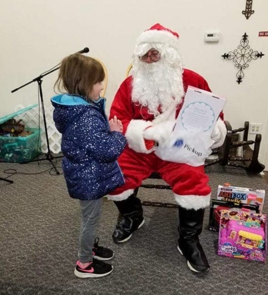 A photo of a child speaking to Santa Claus.