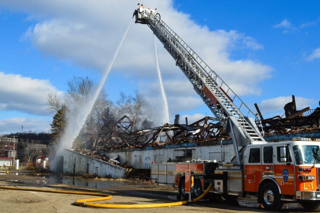 A ladder truck hosing down hot spots.