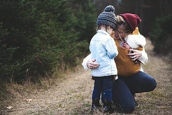 A mother with two kids on a trail.