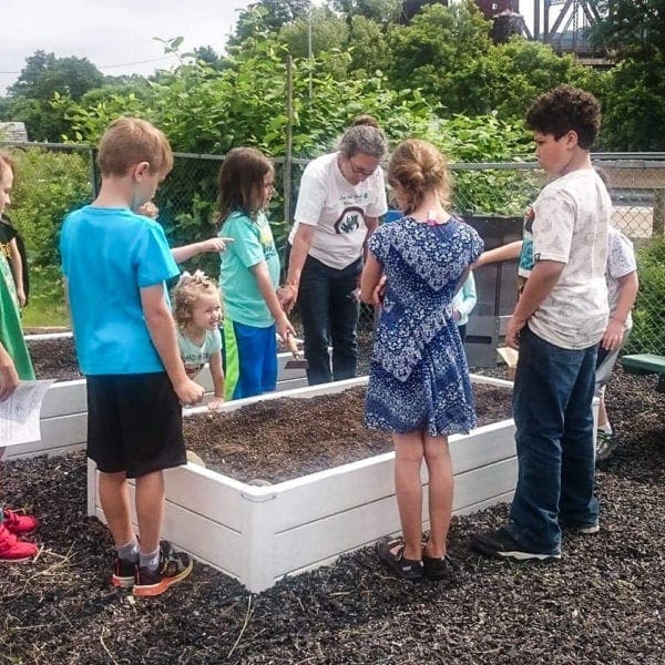 A female farmer is teaching children.