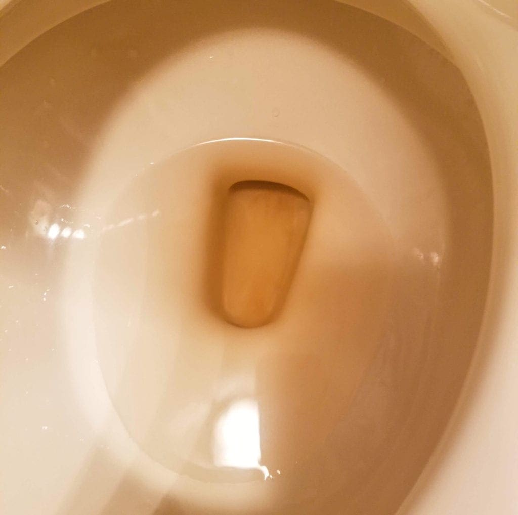 Brown water in a toilet.