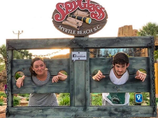 A brother and sister posing for a vacation photo.