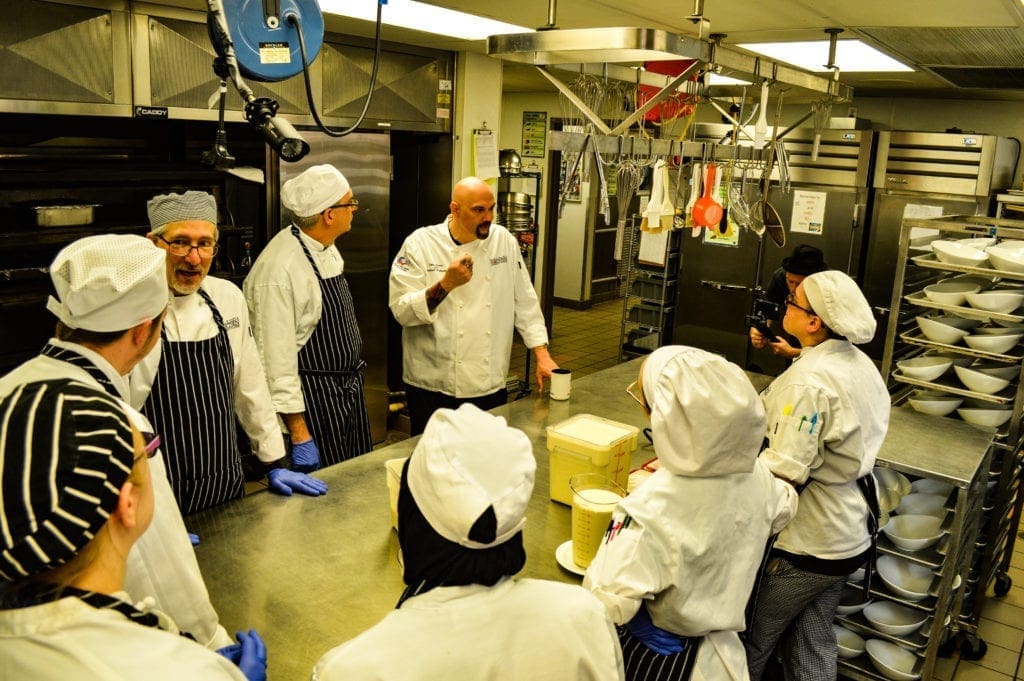 A chef instructing his students.