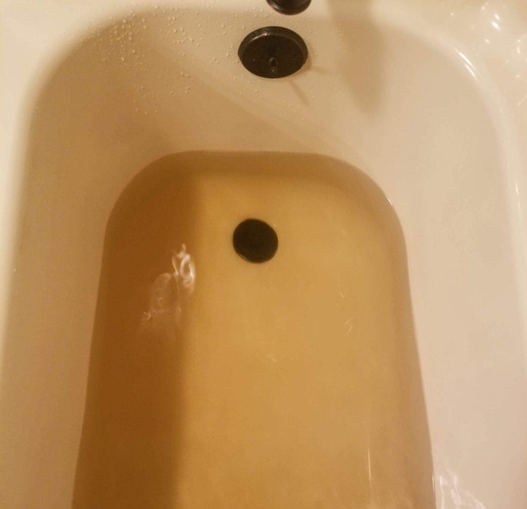 A photo of brown water in a tub.