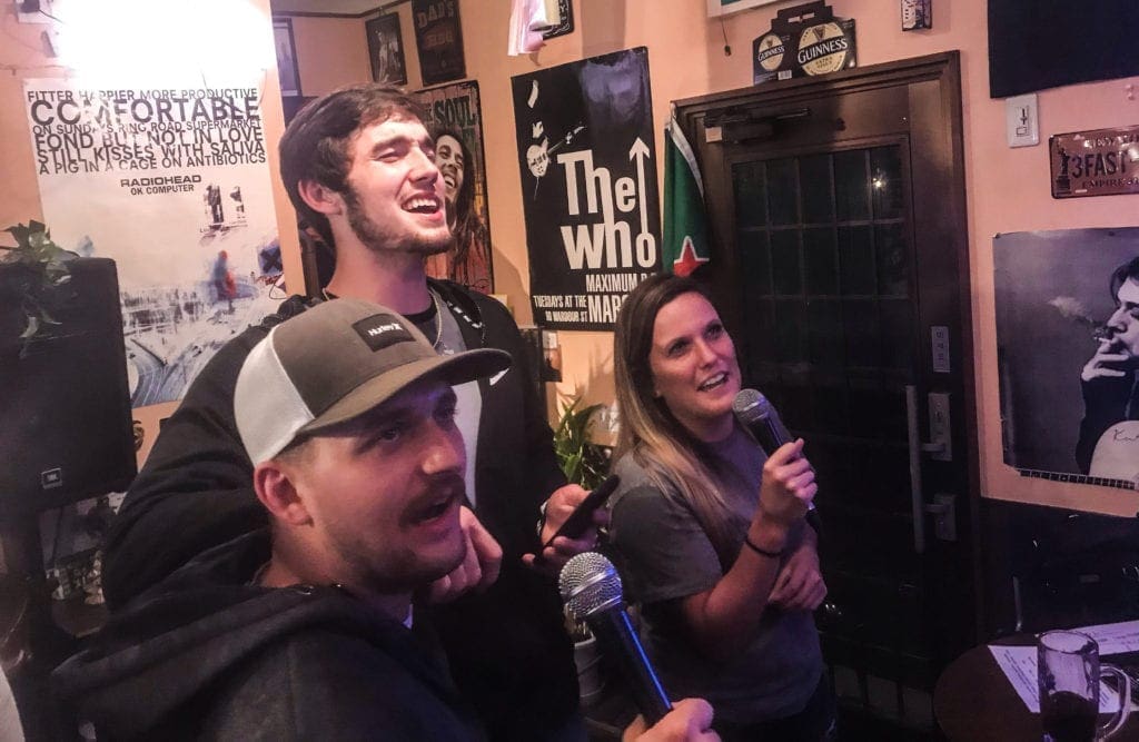 Two young men and a lady singing.