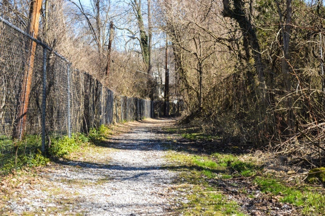 A long trail that is fenced in.