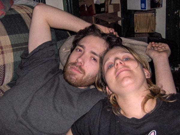 A man and a woman resting on a couch.