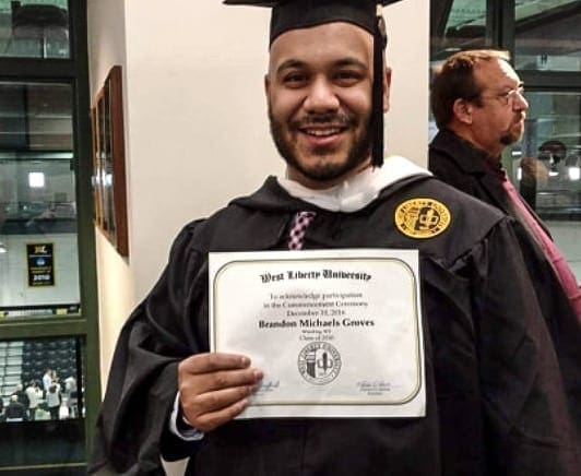 A photo of a man holding a diploma.