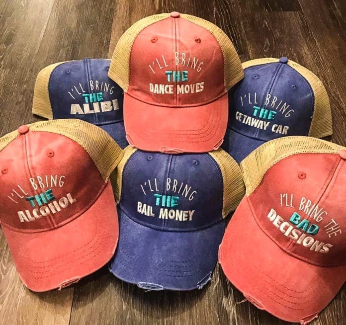 A collection of ball cap that have sassy sayings on them.