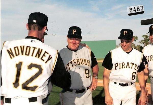 A baseball player shaking the hand of a legend.