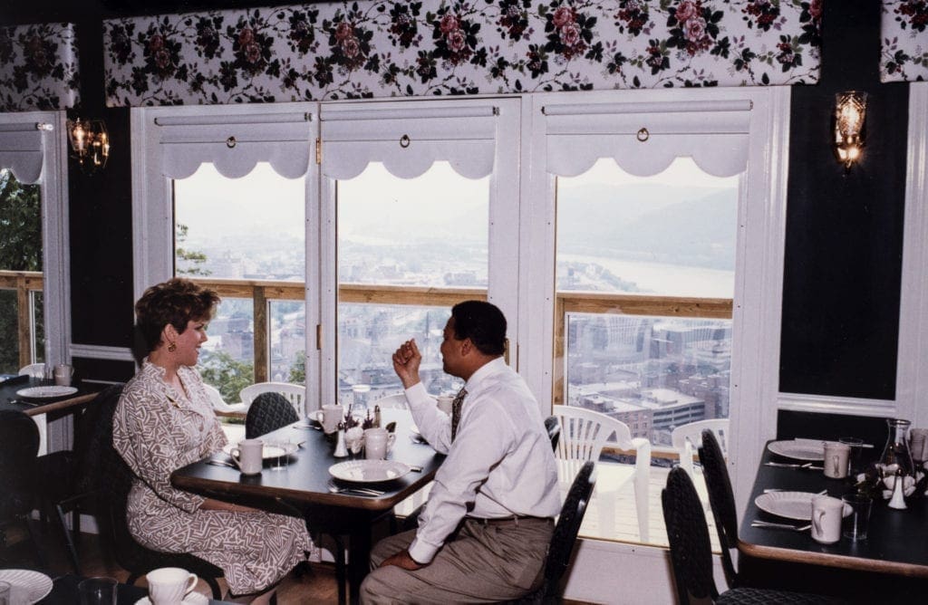 A photo of a man and a woman looking out of a window.