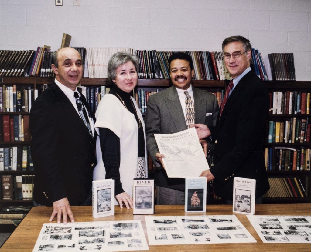 A photo of three men and a woman.