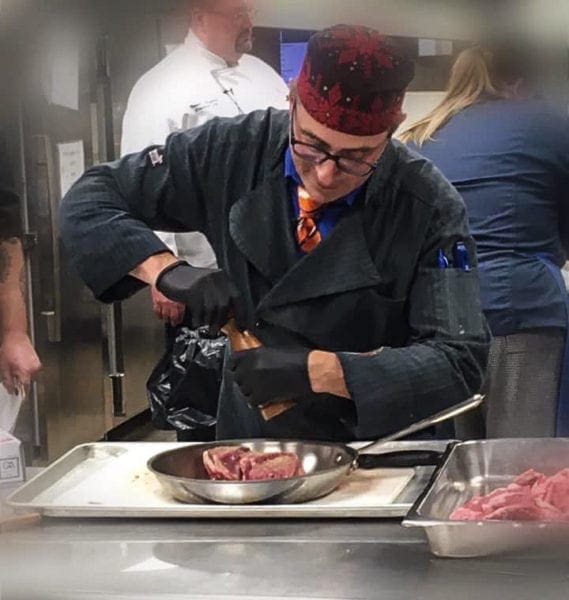 A photo of a chef making steak.