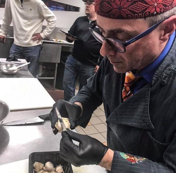 A chef carving a mushroom.