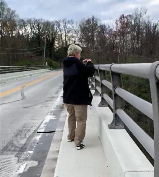 A photo of a lady on a bridge.