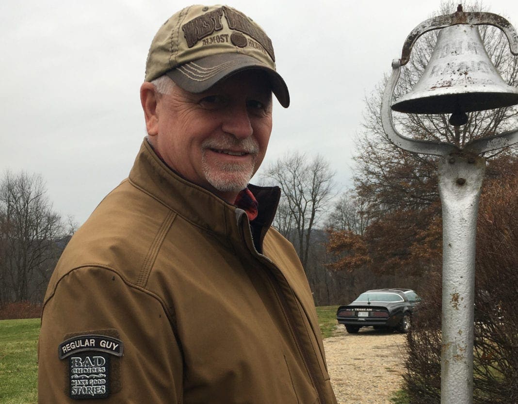 A man near a dinner bell.