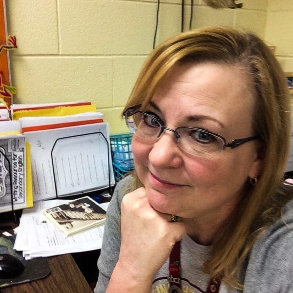 A photo of a lady at a desk.