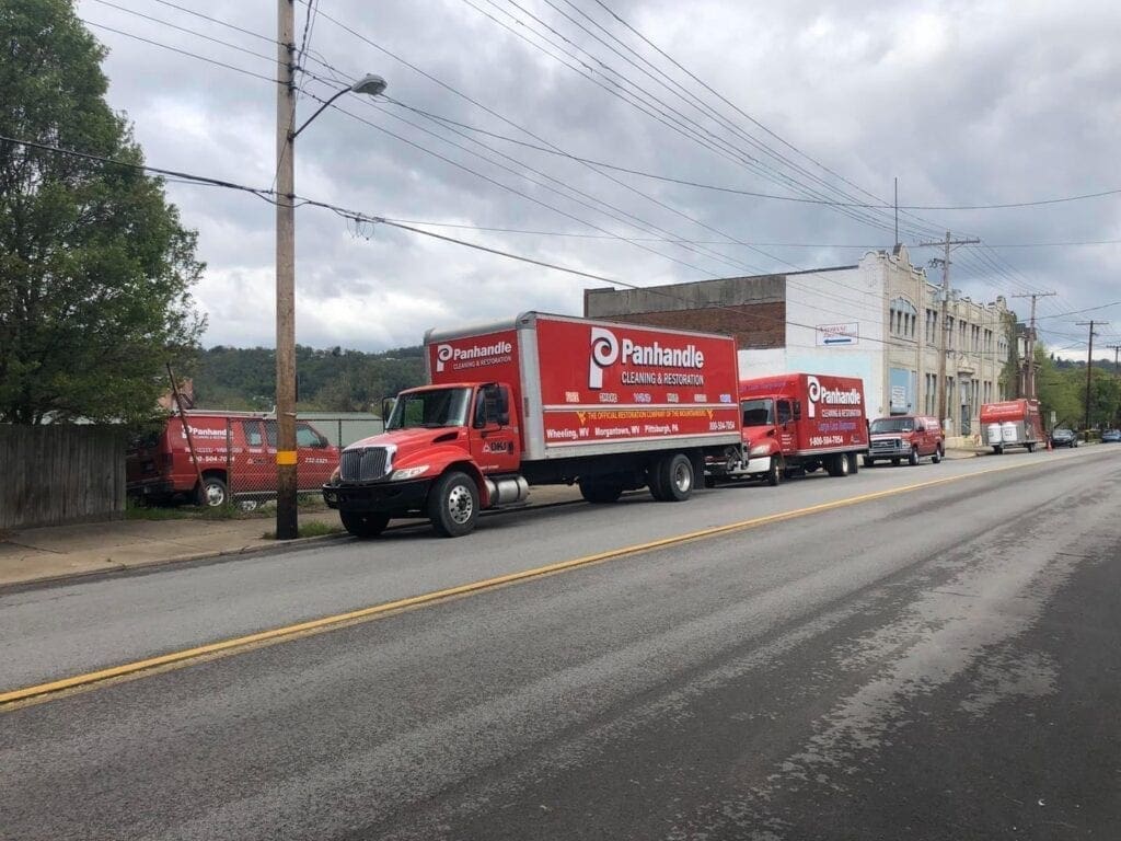 Large red trucks resting in front of a building.