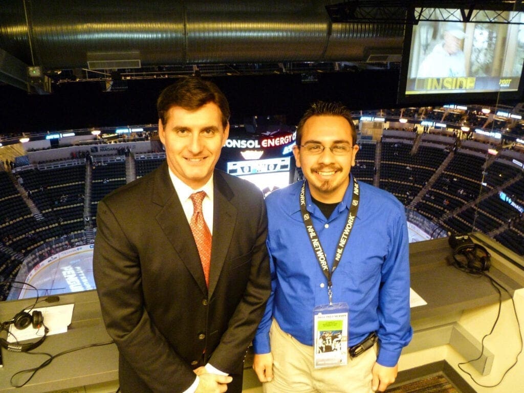 Two broadcasters in a press box.