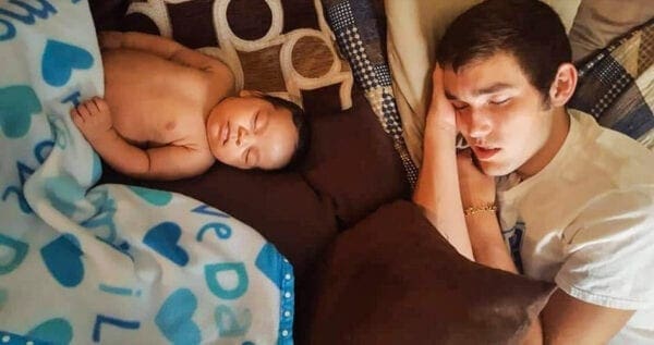 An infant sleeping with his uncle.