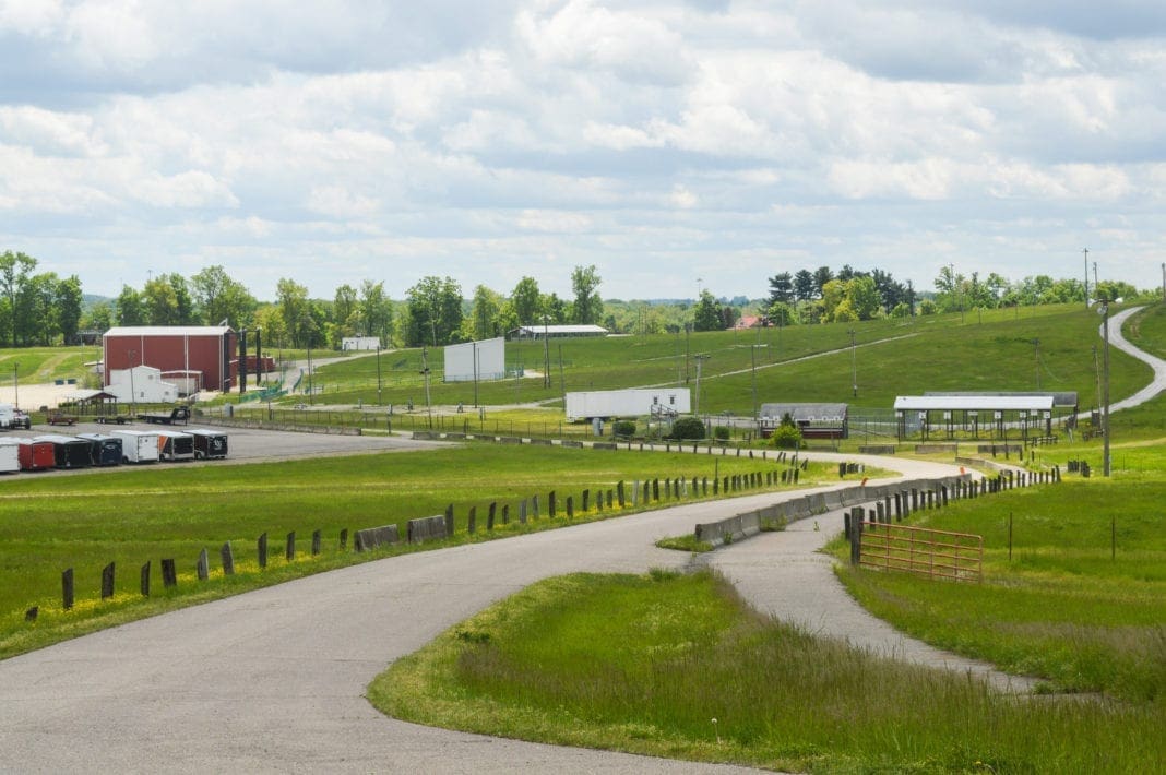 A large field with a barn on it.