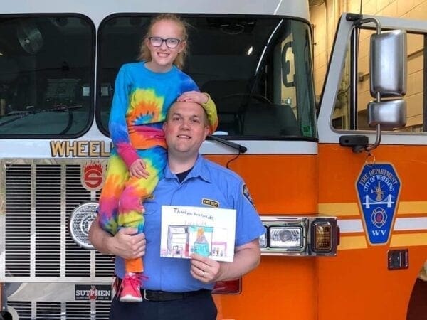 Bob Heldreth holds up his daughter in the fire station