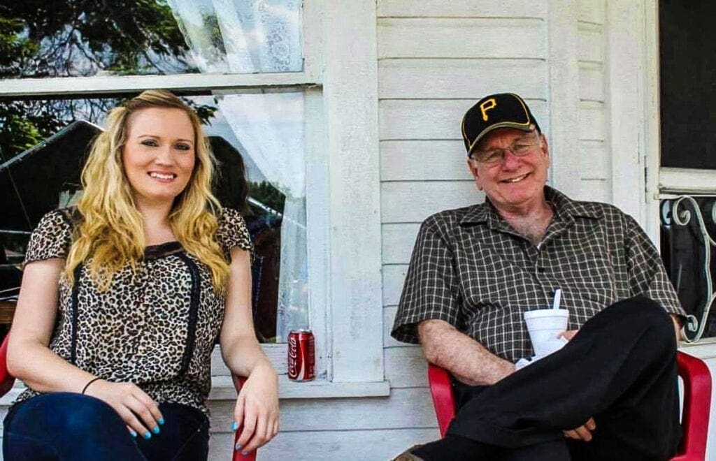 A father and his daughter on the porch.