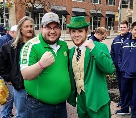 A fan and the Notre Dame mascot in a photo.