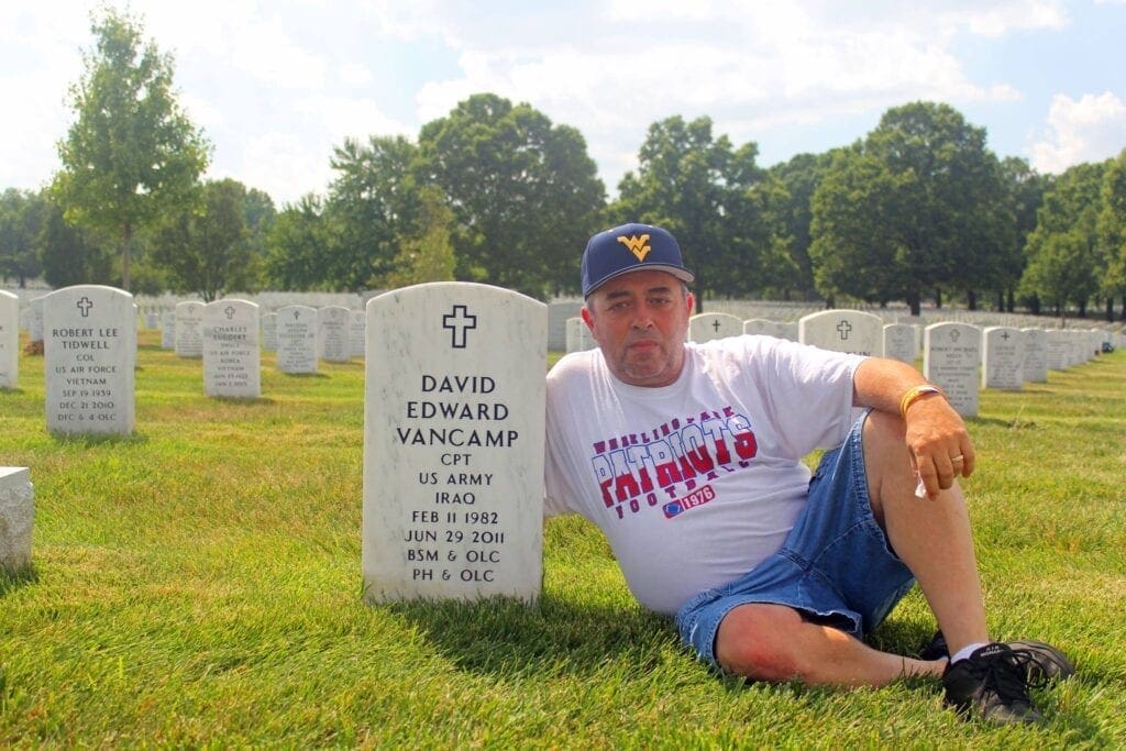 A man next to a grave of s solider.