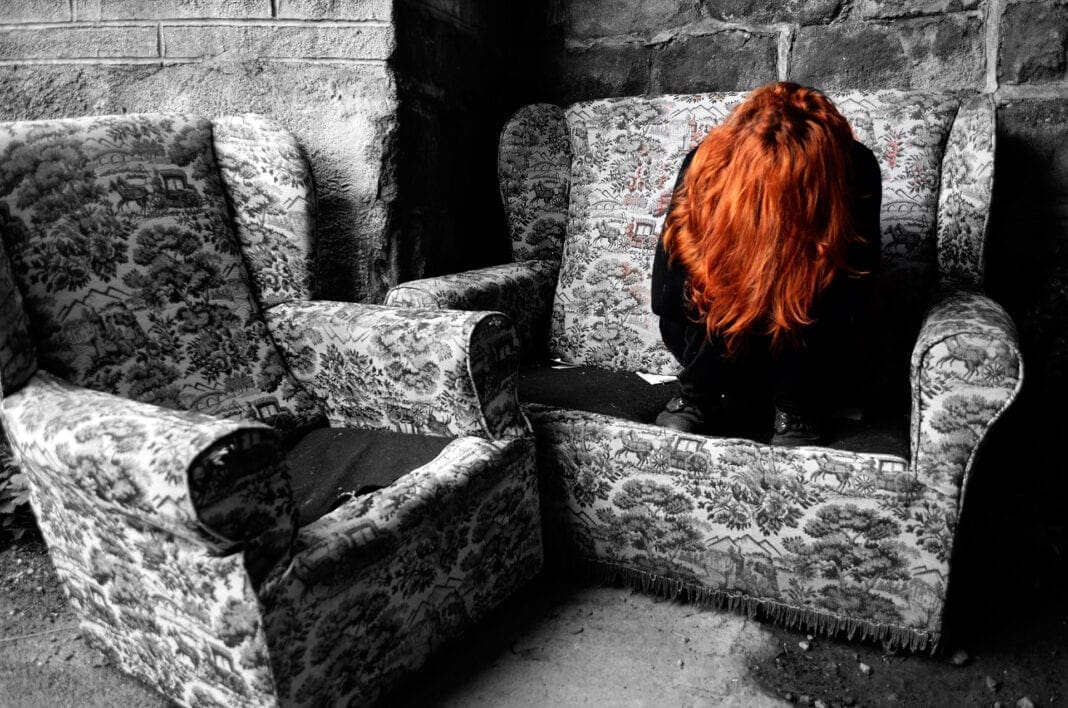 A redhead female sitting in a chair.