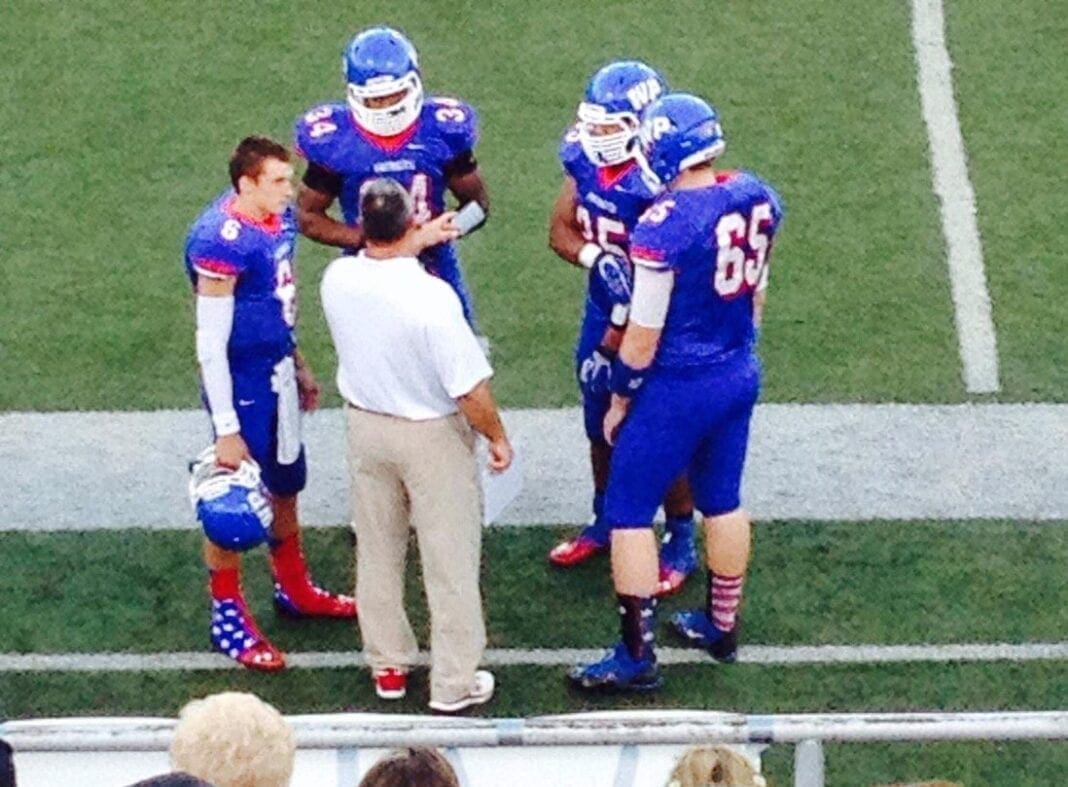 Four players surround a coach.